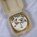 Personalized birthday cookie with cartoon design and 'Happy Birthday Jack' text in a cardboard container.
