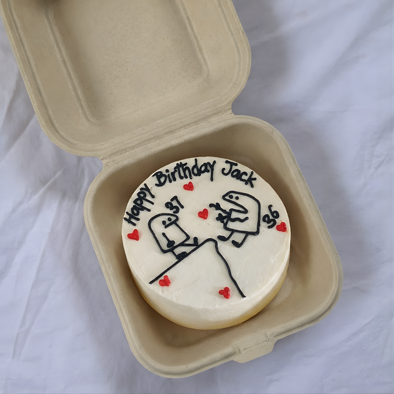 Personalized birthday cookie with cartoon design and 'Happy Birthday Jack' text in a cardboard container.