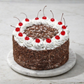 Black Forest Treasure cake with dark chocolate layers, white cream, and fresh red cherries - Toromi Bakehouse