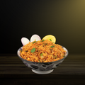 A bowl of Tawa Pulav garnished with onions, lemon, and cilantro.