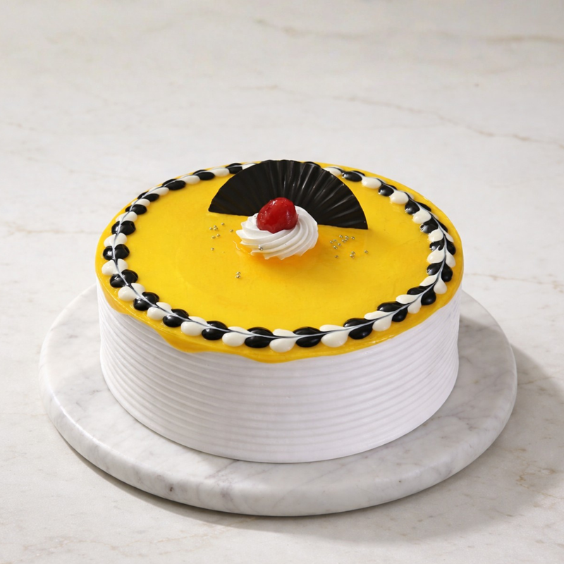 Cherry cake with yellow center, black and yellow piped border, topped with a red cherry and decorative black fan piece.