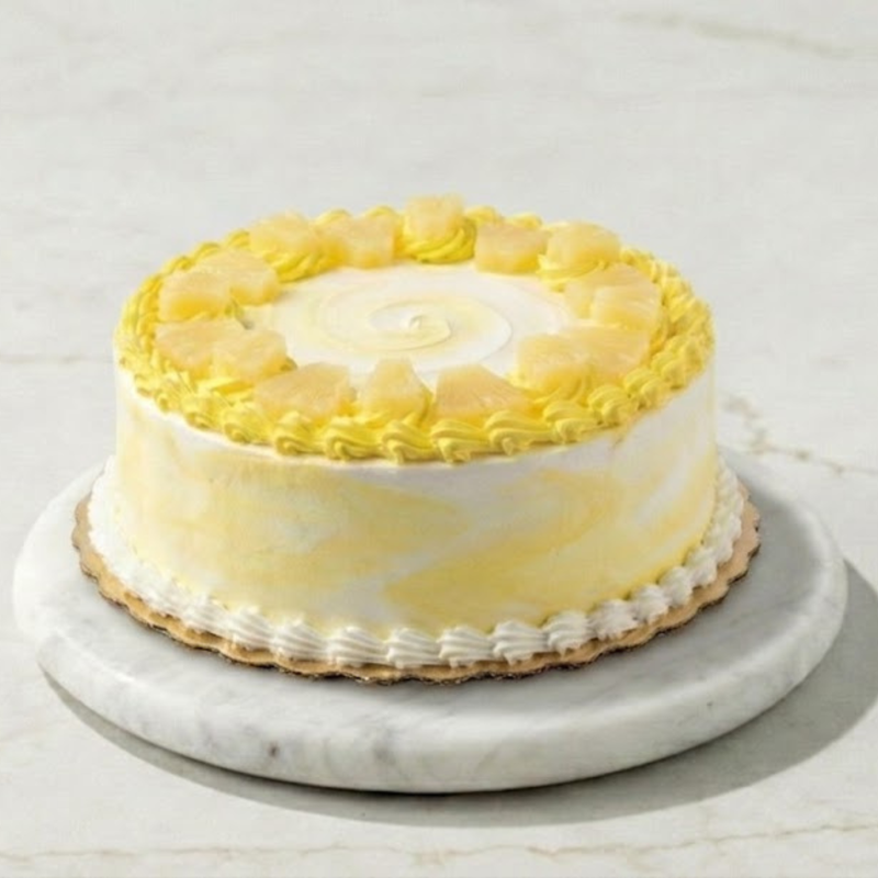 Yellow cake with white frosting on a marble stand